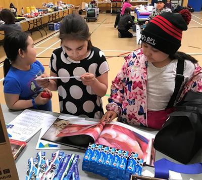 Students from Mangilaluk School examine oral health resources during the Tuktoyaktuk Community Health Fair, February 2020